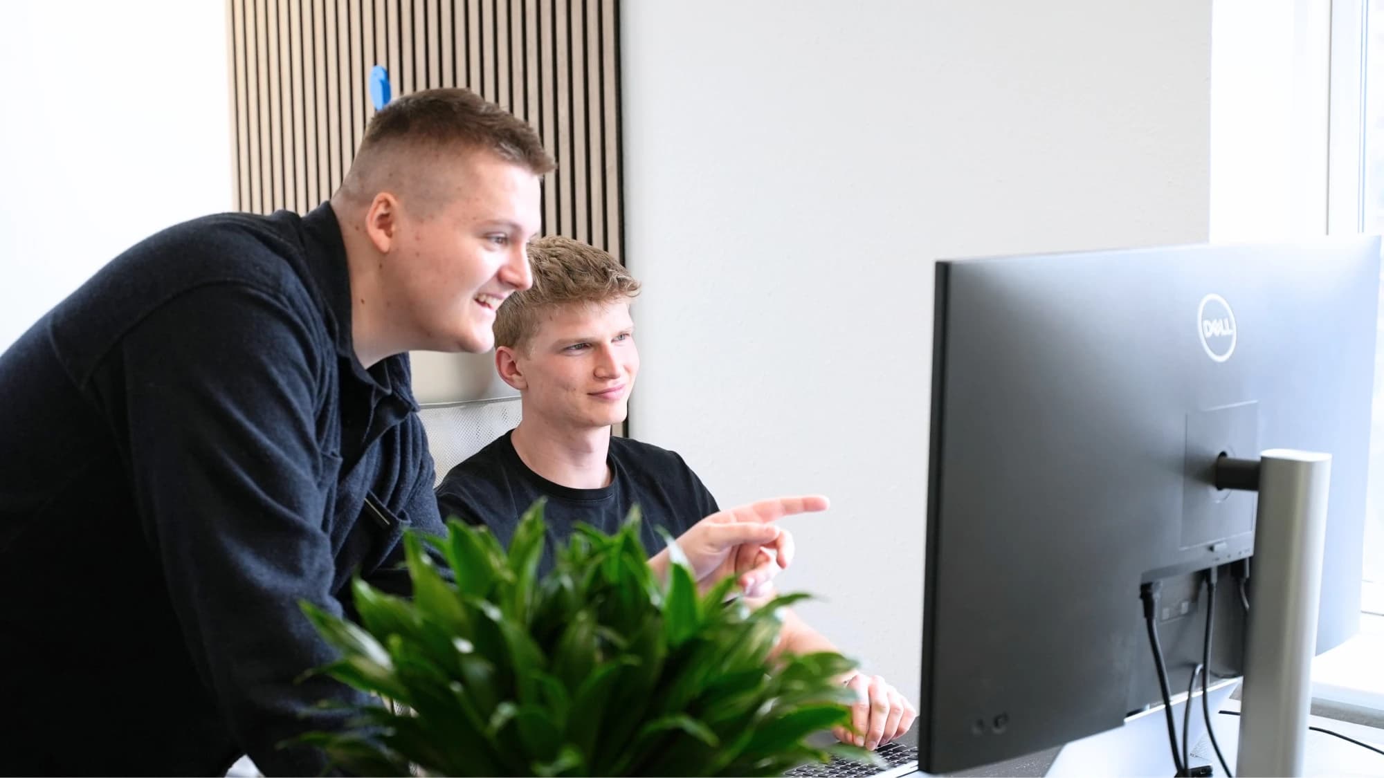 Magnus og Benjamin kigger på en kampagne sammen på kontoret
